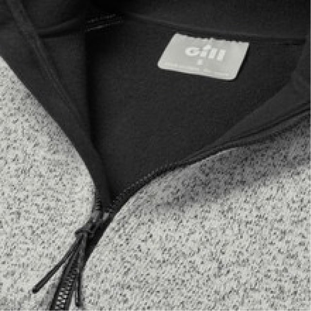 Close-up of a black jacket with a visible brand label on a textured gray surface.