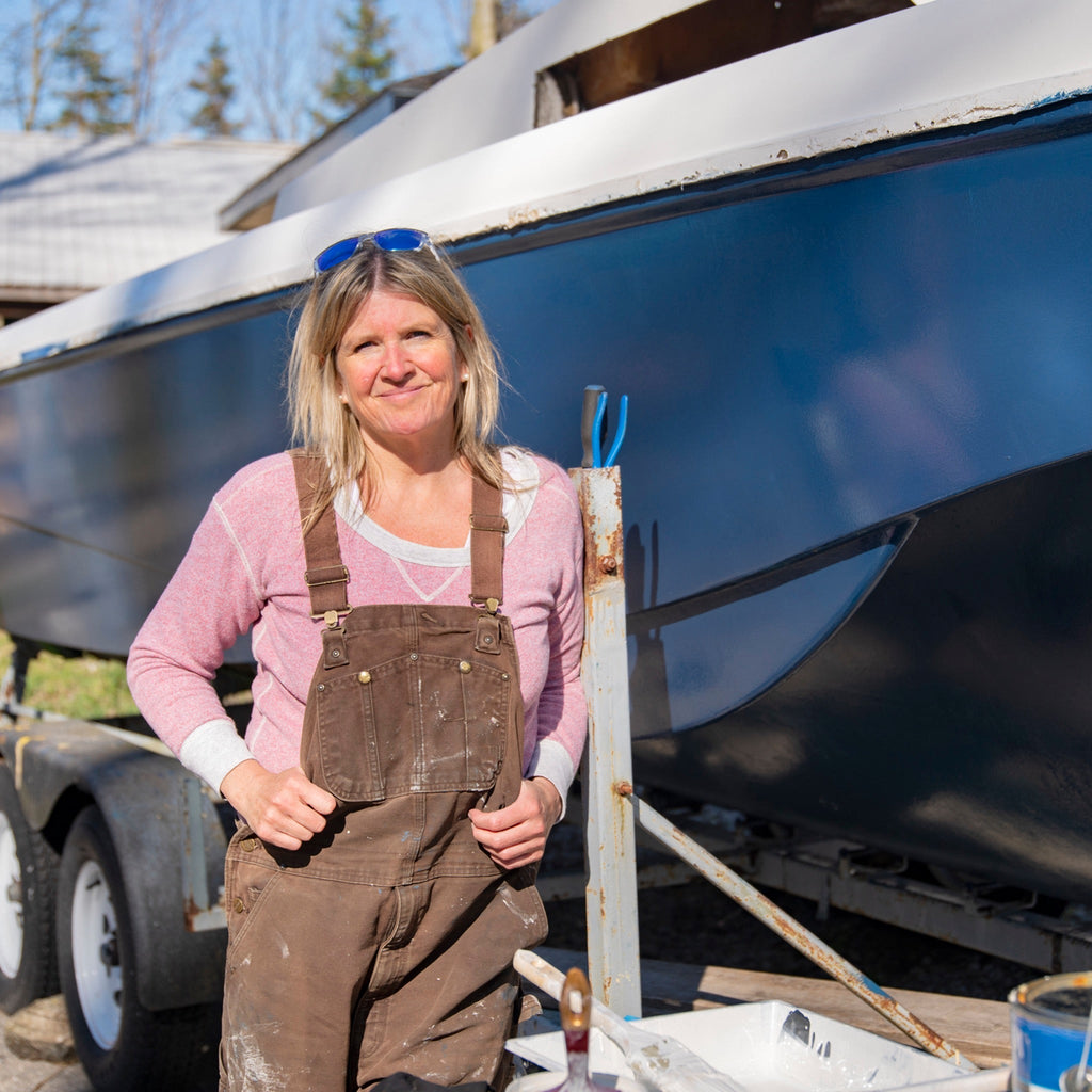 Woman by freshly painted boat.