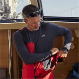 Man wearing a red and black Gill life jacket on a boat