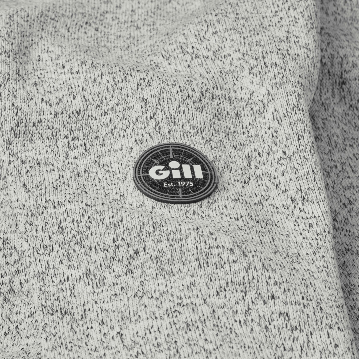 Gill logo on a textured gray fabric background