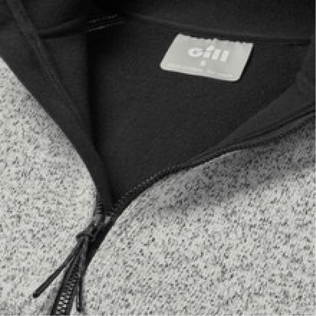 Close-up of a black jacket with a visible brand label on a textured gray surface.