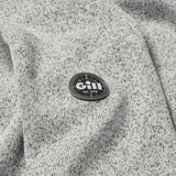 Close-up of a gray textured fabric with a Gill logo patch.