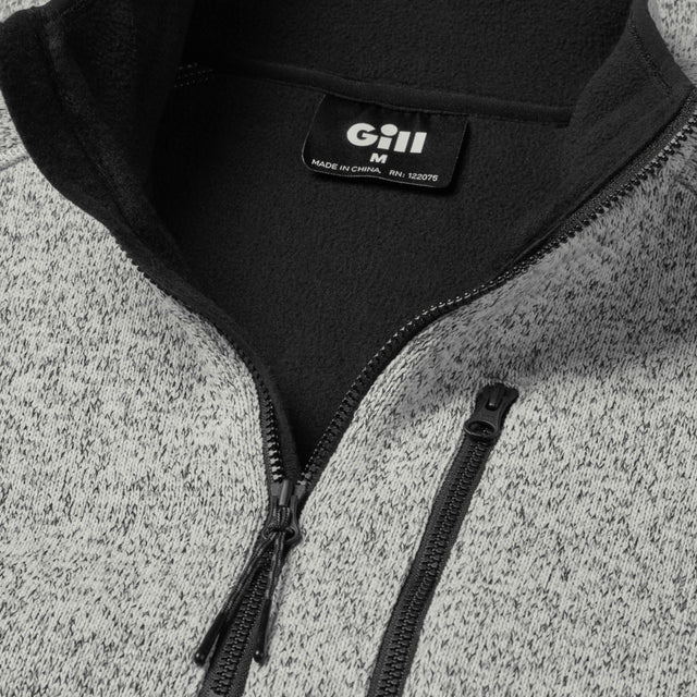 Close-up of a gray and black jacket with a Gill logo on a textured surface