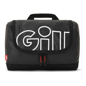 A black quilted GILL travel bag with a large white outlined 'GILL' logo on the front flap, featuring a top carry handle and a small red GILL tag on the left side.