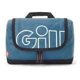 A blue quilted GILL travel pouch with black trim, a black top handle, and a large white outlined 'GILL' logo on the front flap, shown on a white background.