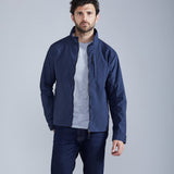 Man wearing a navy blue jacket over a gray shirt on a light gray background