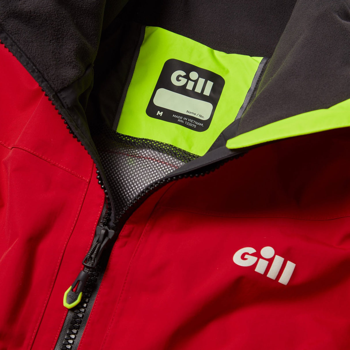 Close-up of a red and black jacket with Gill logo on a green patch.