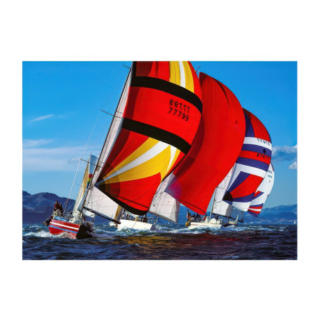 Sailing boat with colorful sails on a blue sky and ocean background
