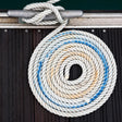 Coiled rope with a knot on a wooden surface