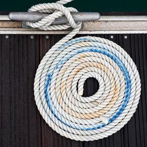 Coiled rope with a knot on a wooden surface